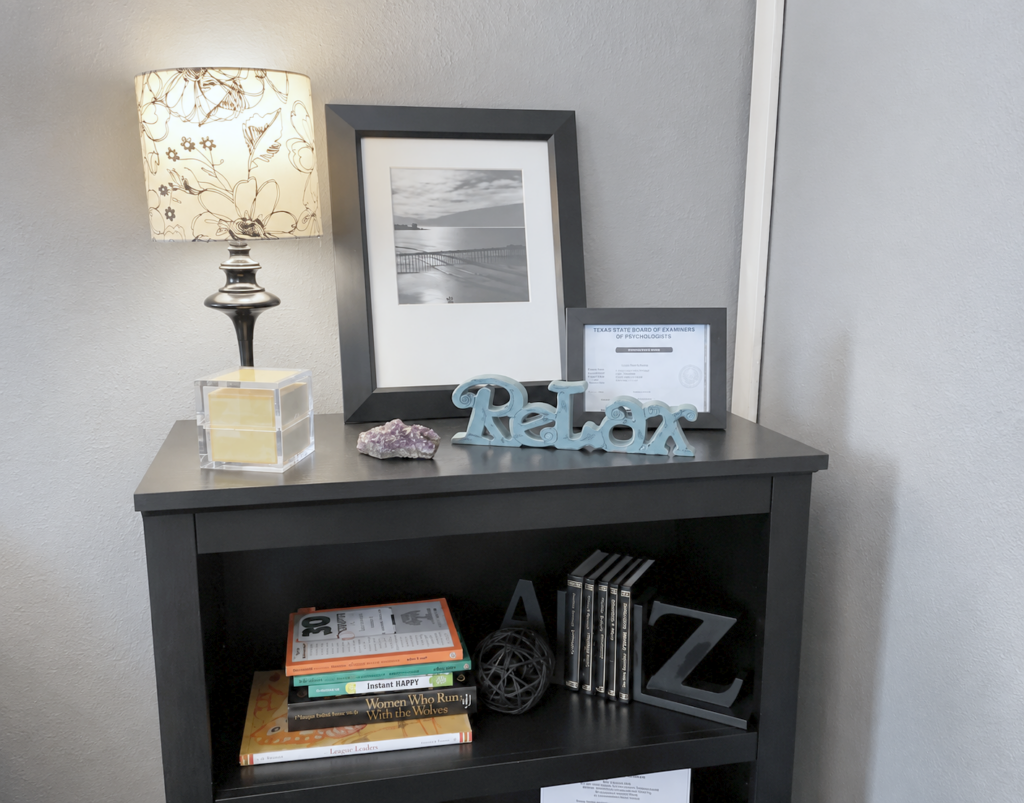 Cozy bookshelf corner with lamp, books, and Relax sign at MBHI
